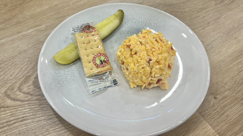 Chicken Salad Chick Southern Pimento Cheese scoop on a plate with crackers and a pickle