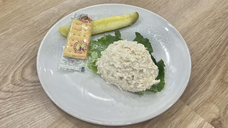 Chicken Salad Chick Classic Carol scoop on a plate with crackers and a pickle