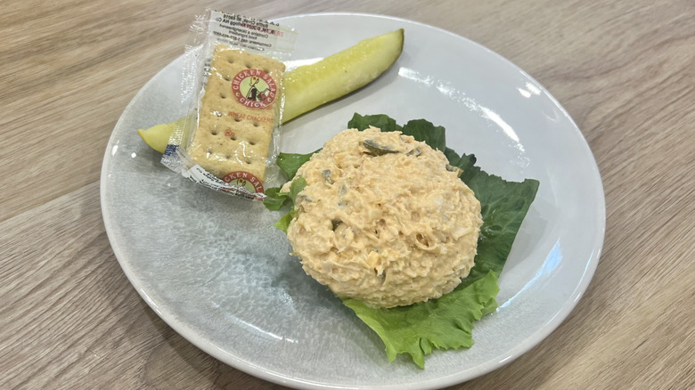 Chicken Salad Chick Kickin' Kay Lynne scoop on a plate with crackers and a pickle
