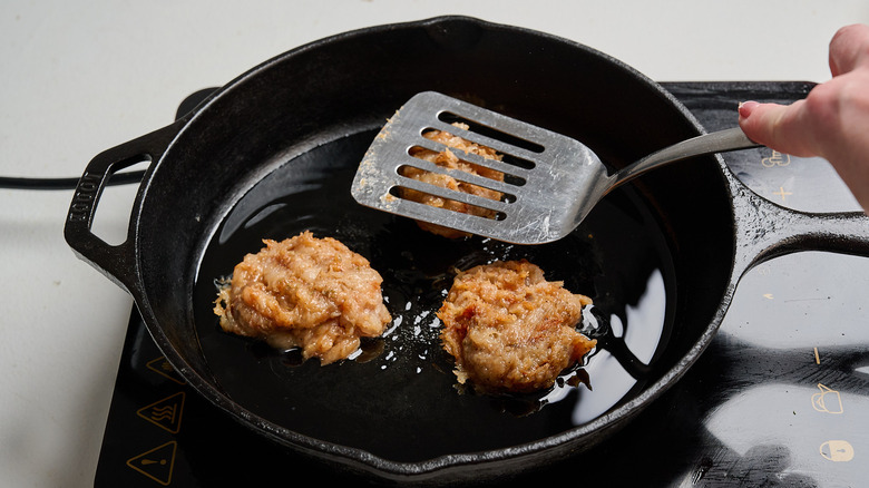 Pressing chicken patties into the skillet
