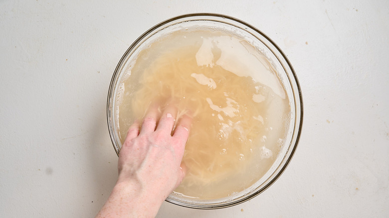rinsing potatoes in a bowl of water
