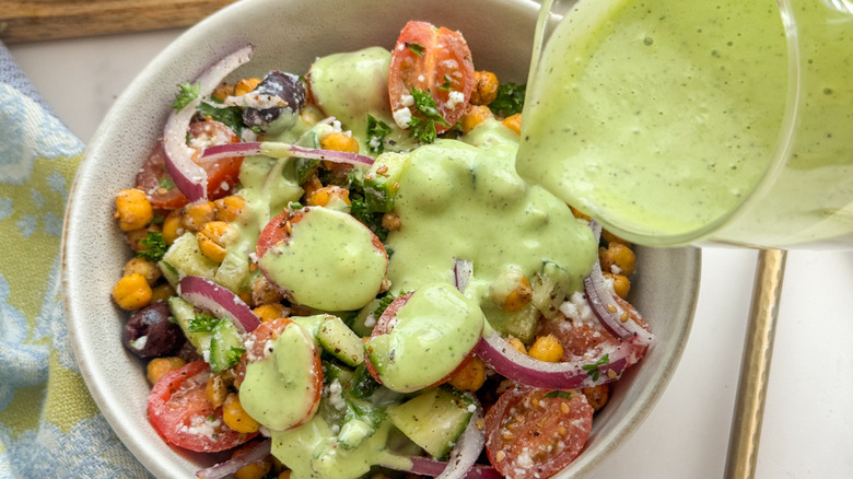 pouring dressing over chickpea salad