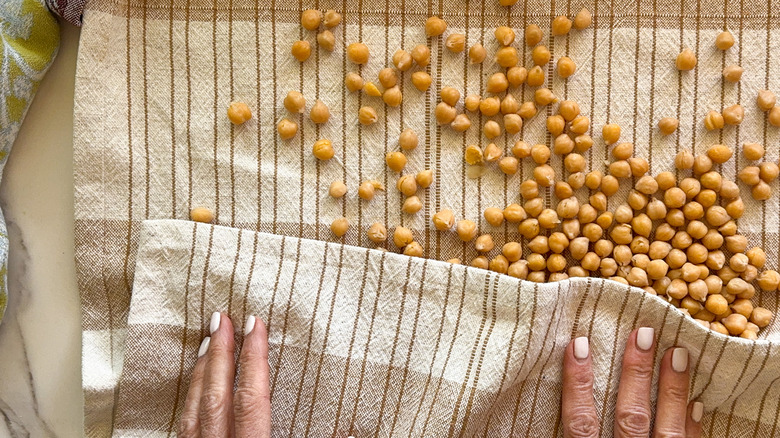 hands drying chickpeas with towel