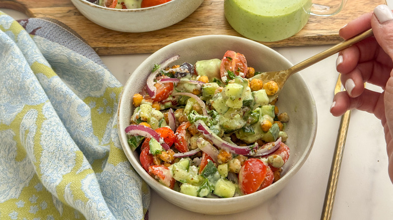 hand getting forkful of salad