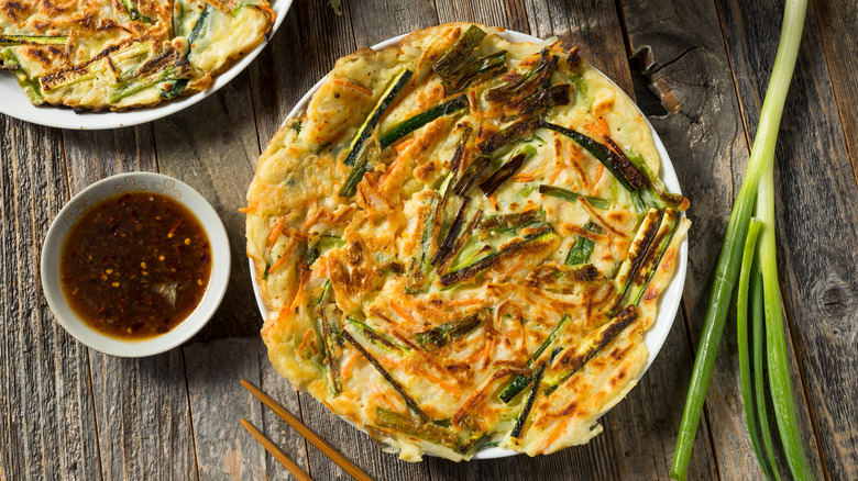 Korean scallion pancake on a plate with dipping sauce
