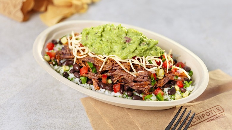 Chipotle burrito bowl with chips and napkin