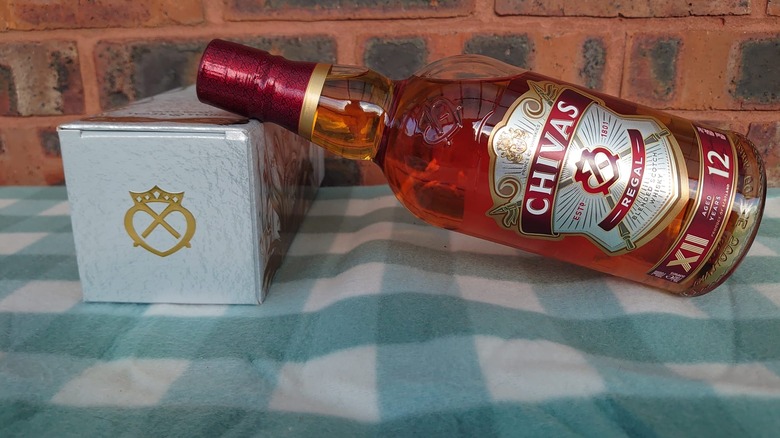 A bottle of Chivas Regal 12-year resting on the top of a laid down box