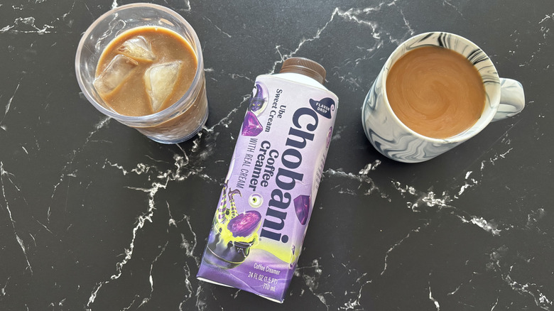 Chobani Ube Sweet Cream creamer bottle in between glass of iced coffee and hot coffee