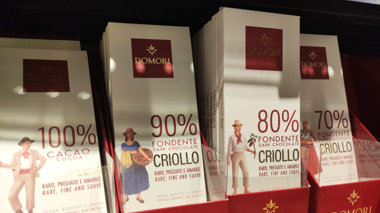 Four chocolate bars from the brand Domori with varying cacao percentages on store display
