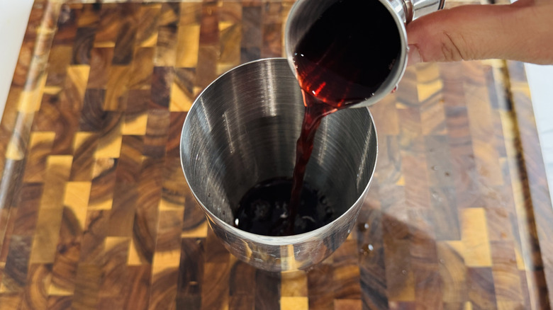 Cherry juice pouring into cocktail shaker