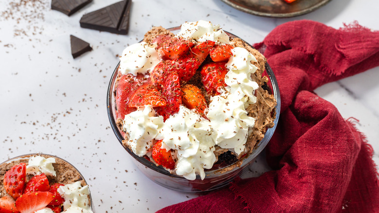Focus on a serving of chocolate strawberry trifle with chocolate on the side.