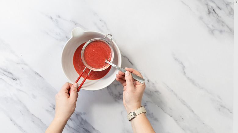 Straining strawberry coulis