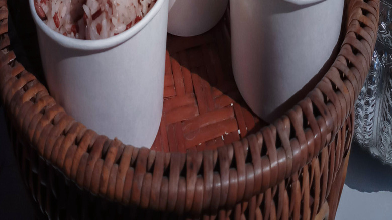 A funeral offering including bowls of rice with incense sticks stuck in them