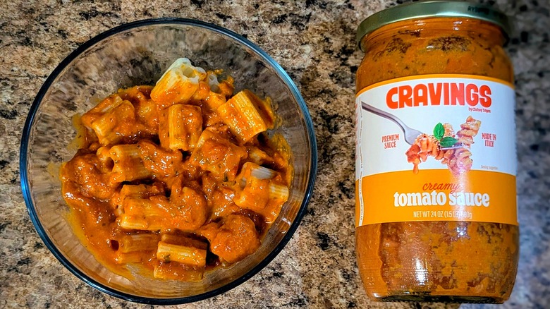 Cravings by Chrissy Teigen Creamy Tomato pasta sauce on pasta next to jar