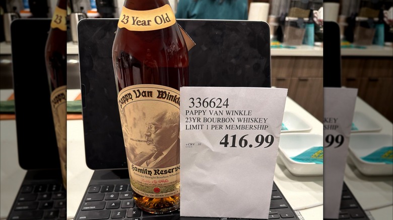 A bottle of Pappy Van Winkle 23 on a laptop with its Costco price tag