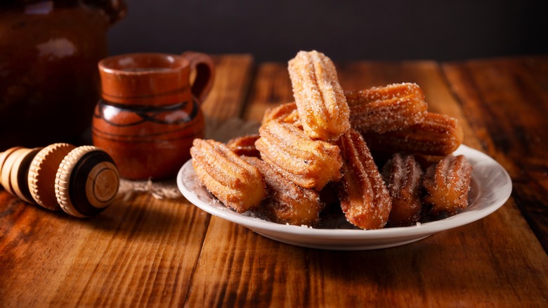 plate of churros on a wood table 