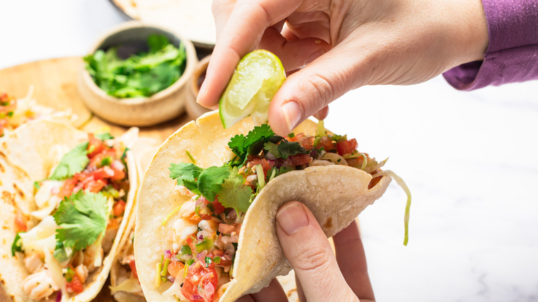 Adding lime to a shrimp taco.