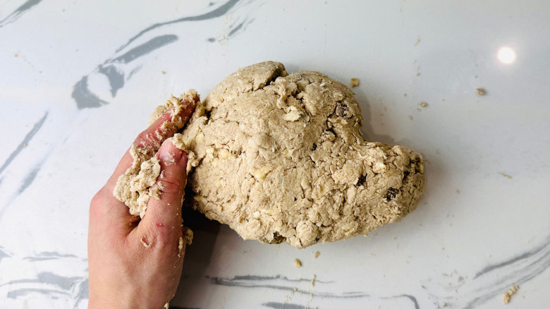 Hand holding shaggy biscuit dough