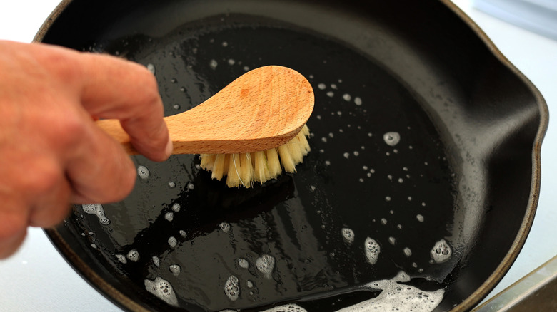Cleaning a cast iron pan with a brush