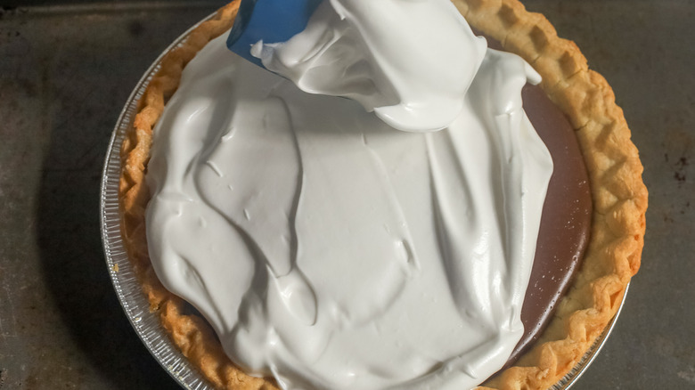 chocolate pudding pie partially covered with meringue