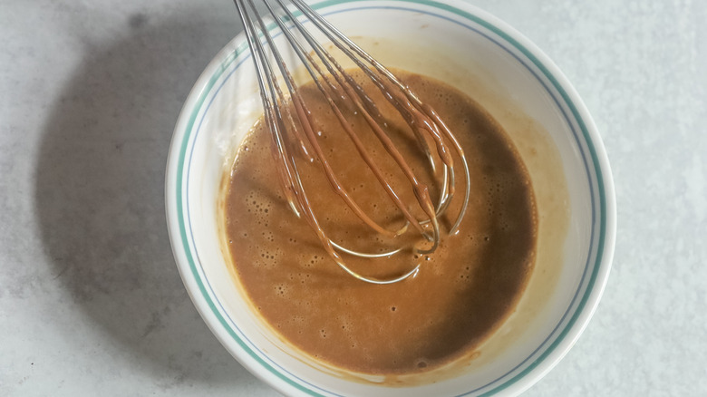 liquid chocolate mixture and whisk in white bowl