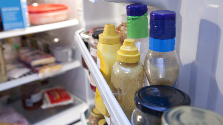 bottles of condiments in fridge