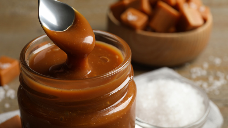 caramel sauce in a jar on a spoon