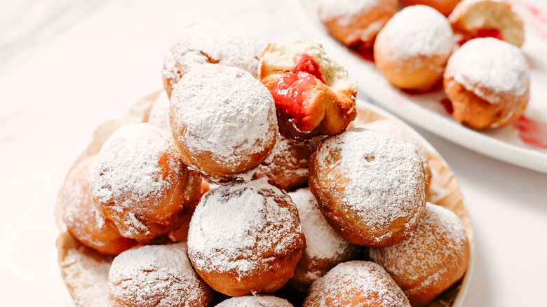 Plate full of raspberry sufganiyot with more in background