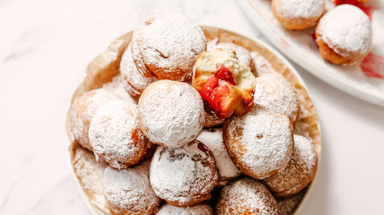 Plate full of raspberry sufganiyot with more in background