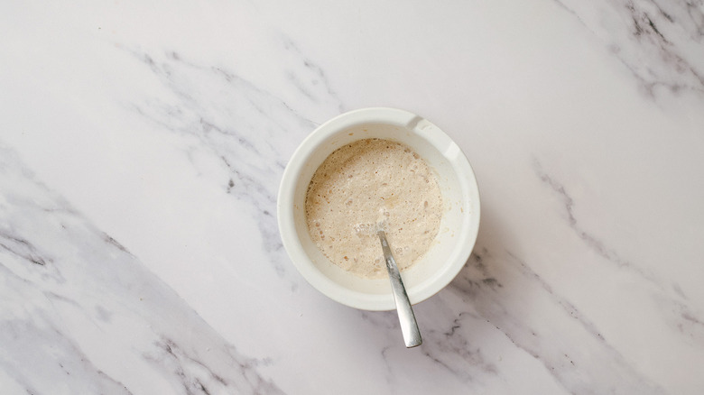 Yeast mix in bowl with spoon