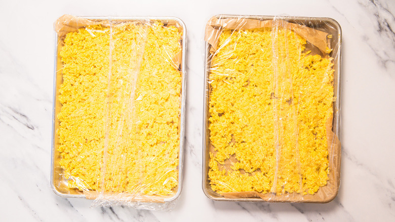 Cooled saffron risotto divided among two baking sheets