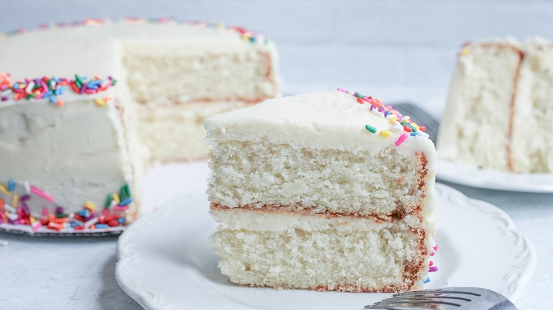 slice cut from frosted white layer cake