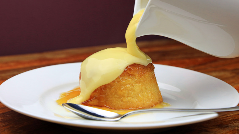 Cream poured over treacle pudding