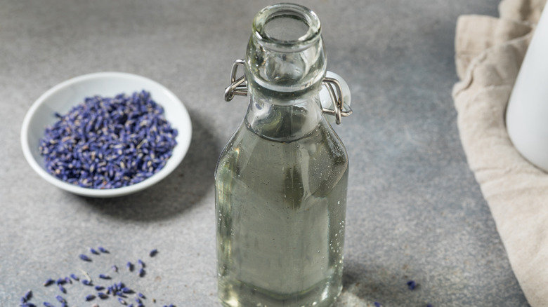 Glass bottle of simple syrup with bowl of lavender