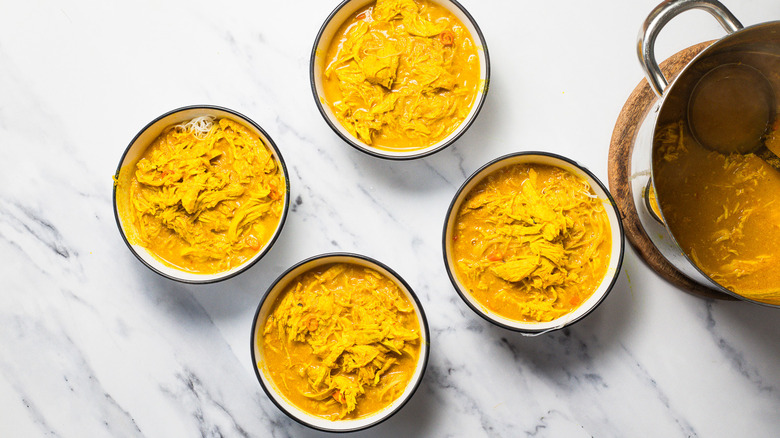 Four bowls of chicken noodle soup.