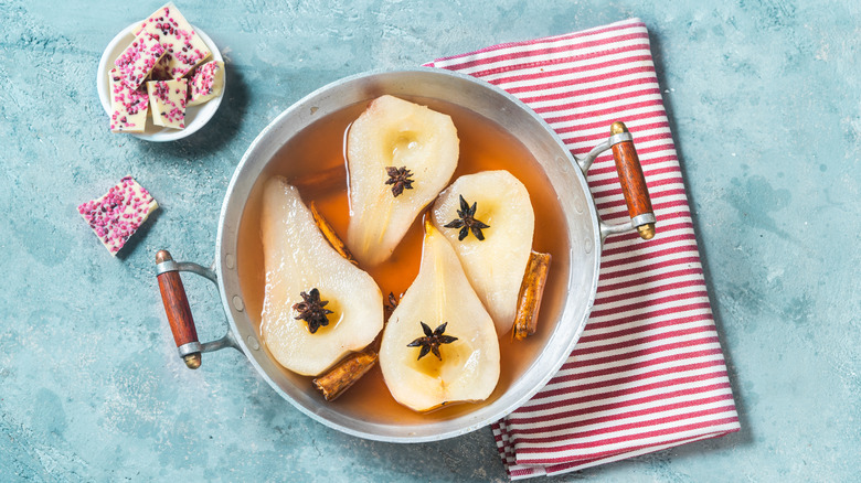 Pears being poached with cinnamon and star anise