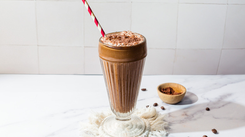 Glass with frothy egg cream with red and white straw