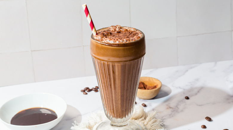 Glass with frothy egg cream with red and white straw