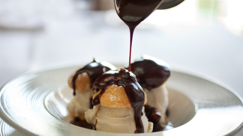 Chocolate sauce drizzled over profiteroles