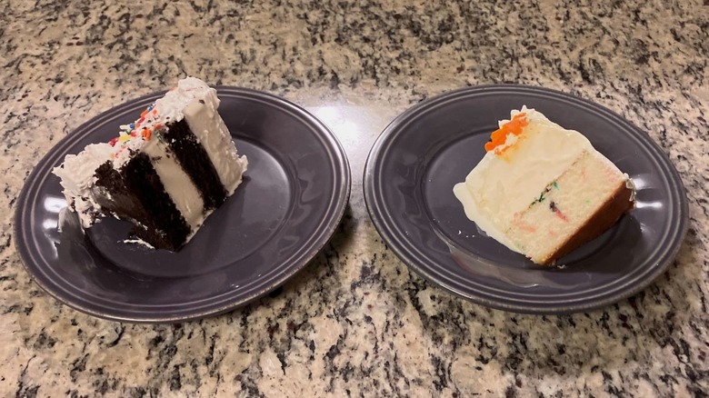 A slice of Cold Stone Creamery's Birthday Cake sits on a purple plate on the left and a slice of Baskin-Robbins' Celebration Party Cake sits on a purple plate on the right