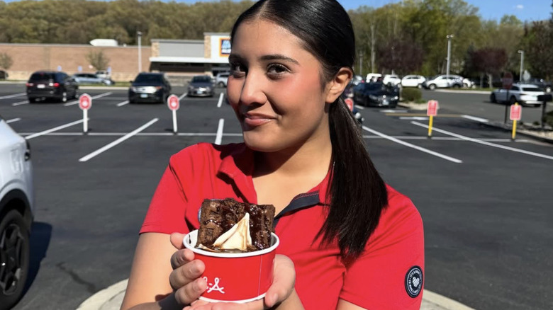 woman holding sundae in cup