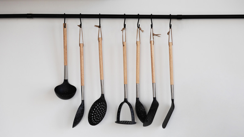 Various kitchen utensils hang from a rod