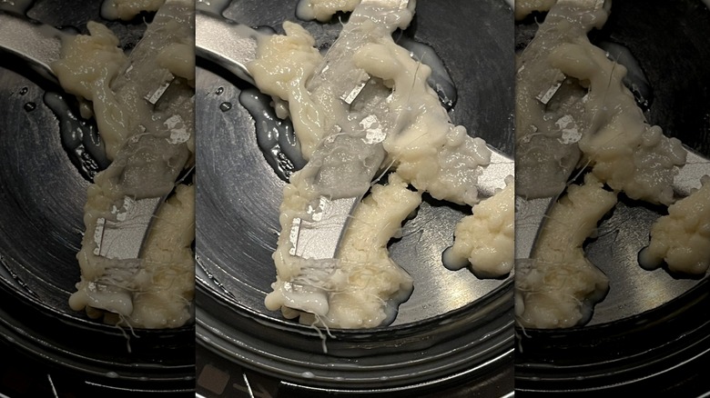 Inside of Ninja CREAMi showing plastic shreds mixed with ice cream