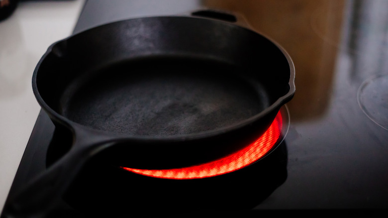 Cast iron skillet heating on a glass cooktop