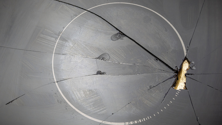 Badly cracked glass cooktop, with the underlying electric heating element clearly visible through the shattered area