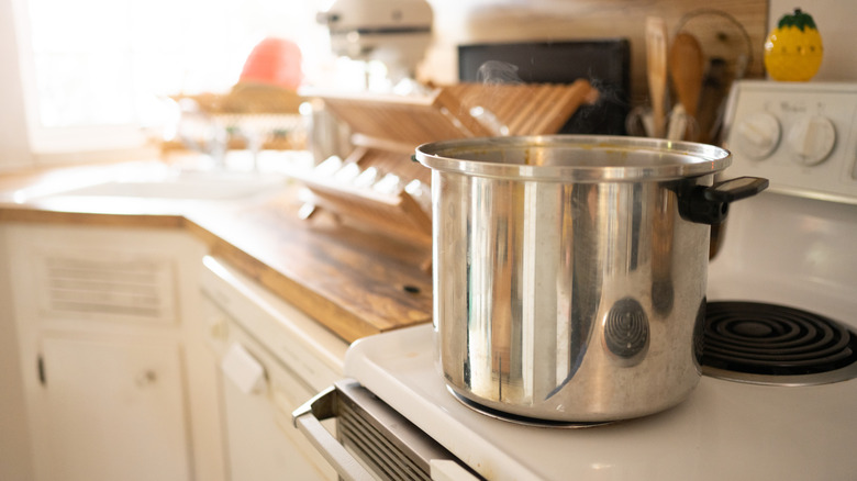 Large pot on the small front burner of an electric coil stove