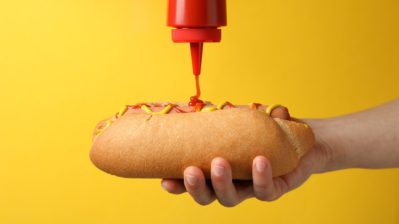 ketchup pouring on a hot dog