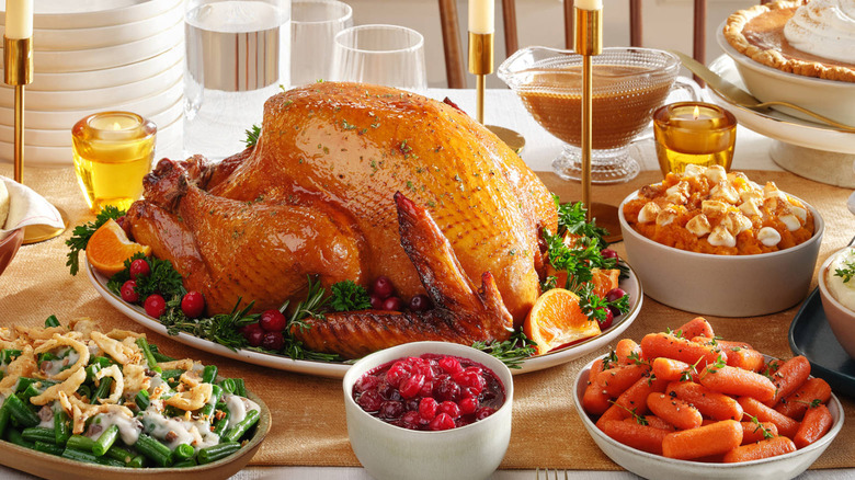 A turkey with sides, including carrots and green beans