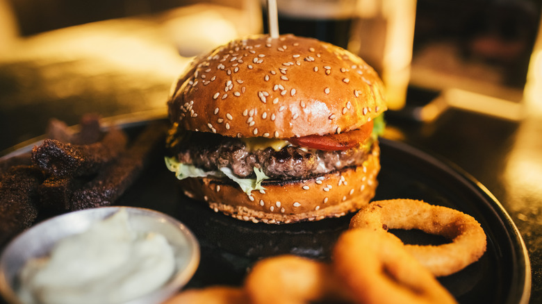 burger with onion rings and mayo in ramken