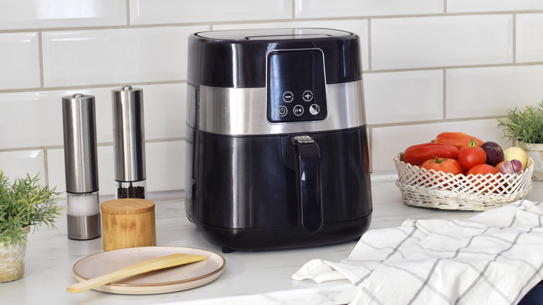 Air fryer on countertop with white tile backsplash